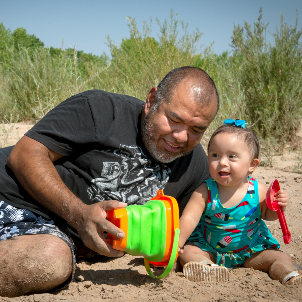 dad playing with his daughter on the beach