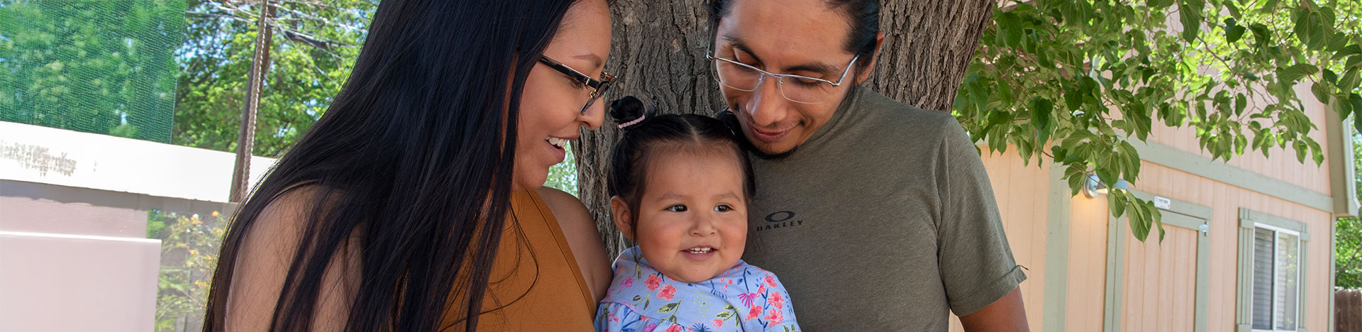 parents holding their happy baby outside